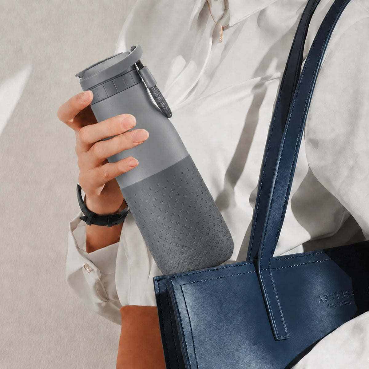 Botella joki 500 gris, calidad premium, en la cartera de una mujer